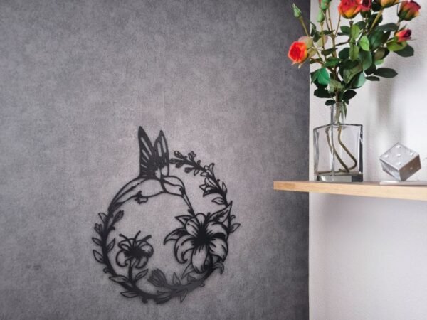 Detailansicht Kolibri Wandmotiv aus Metall, zeigt filigrane Blumen und schwarzen Umriss